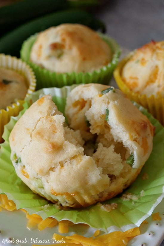 Jalapeno Cheese Muffins are the perfect side to many main meals like soups or chili. A close up picture of a jalapeno cheese muffin split in half with whole muffins around it.