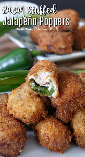 Stuffed Jalapeño Poppers are seriously so crispy, delicious and stuffed full of cream cheese, crispy bacon, shredded cheese and green onions. Stuffed jalapeno poppers stacked up on a white plate with a bite taken out of one of them, with green onions and a jalapeno in the background, and another white plate with jalapeno poppers stacked up.