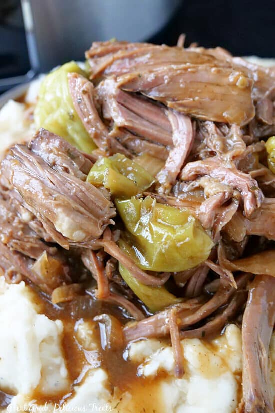 A super close up photo of tender Mississippi Pot Roast that is served over mashed potatoes.