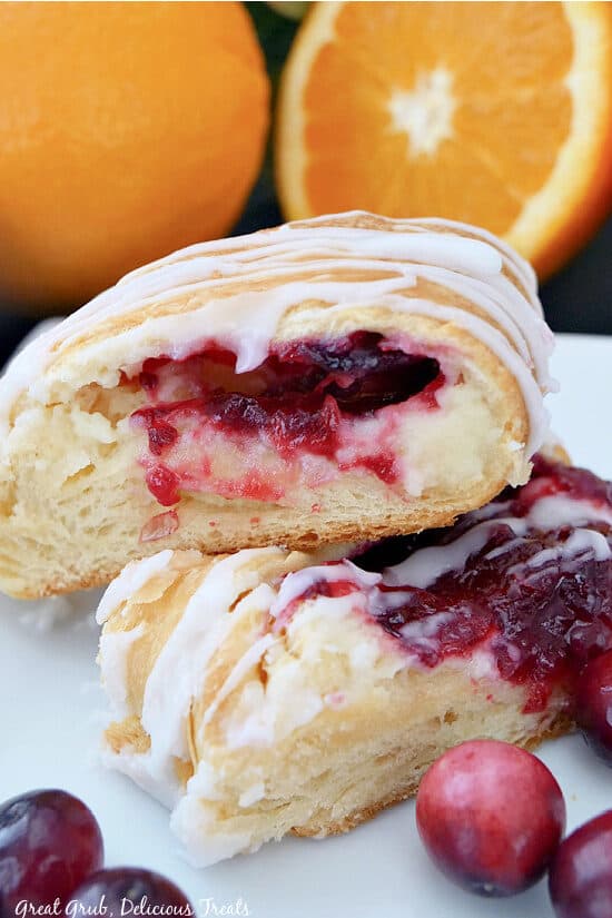 A close up photo of two slices of cranberry cheese pastry on a white plate.