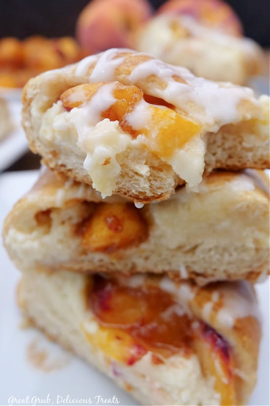Three pieces of pastry stacked up on a plate with a bite taken out of the top piece.