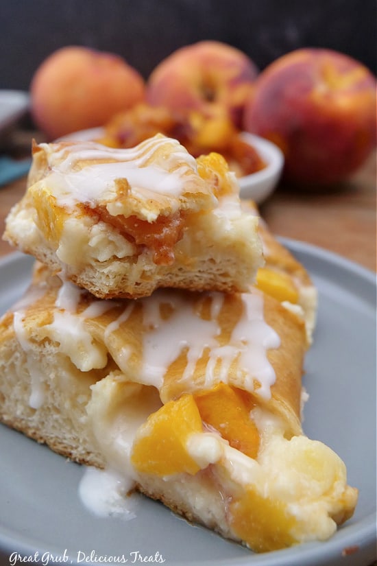 A light blue plate with two pieces of peach pastry on it.
