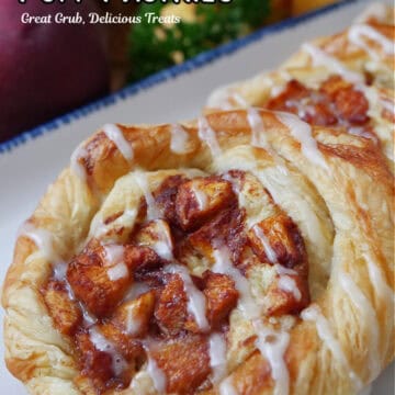 A close up of a couple peach pastries on a white plate with blue trim.