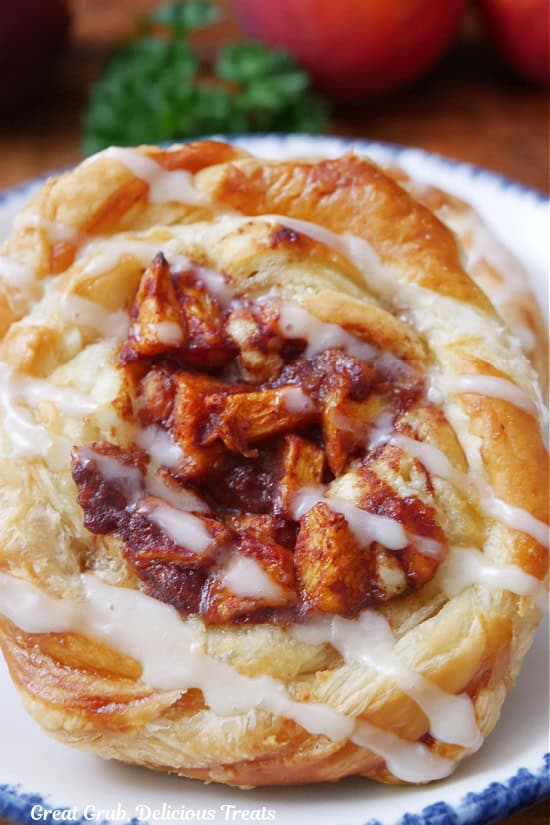 A close up photo of a peach puff pastry danish.