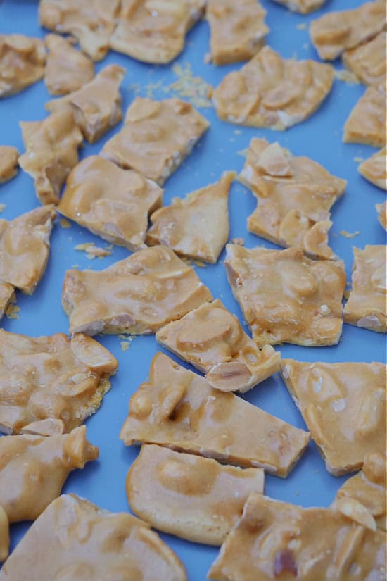 A blue baking sheet with peanut brittle broke into pieces.