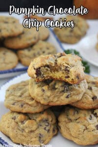 A white counter with pumpkin chocolate chip cookies on it.