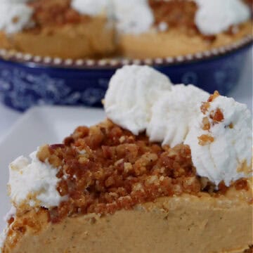 A white plate with a slice of pumpkin cream cheese pie on it.