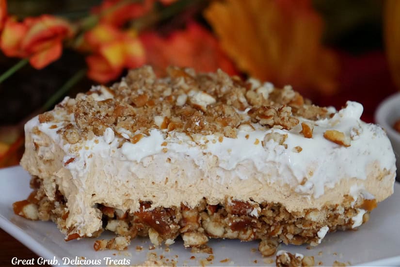 A white plate with a piece of pumpkin dessert on it.