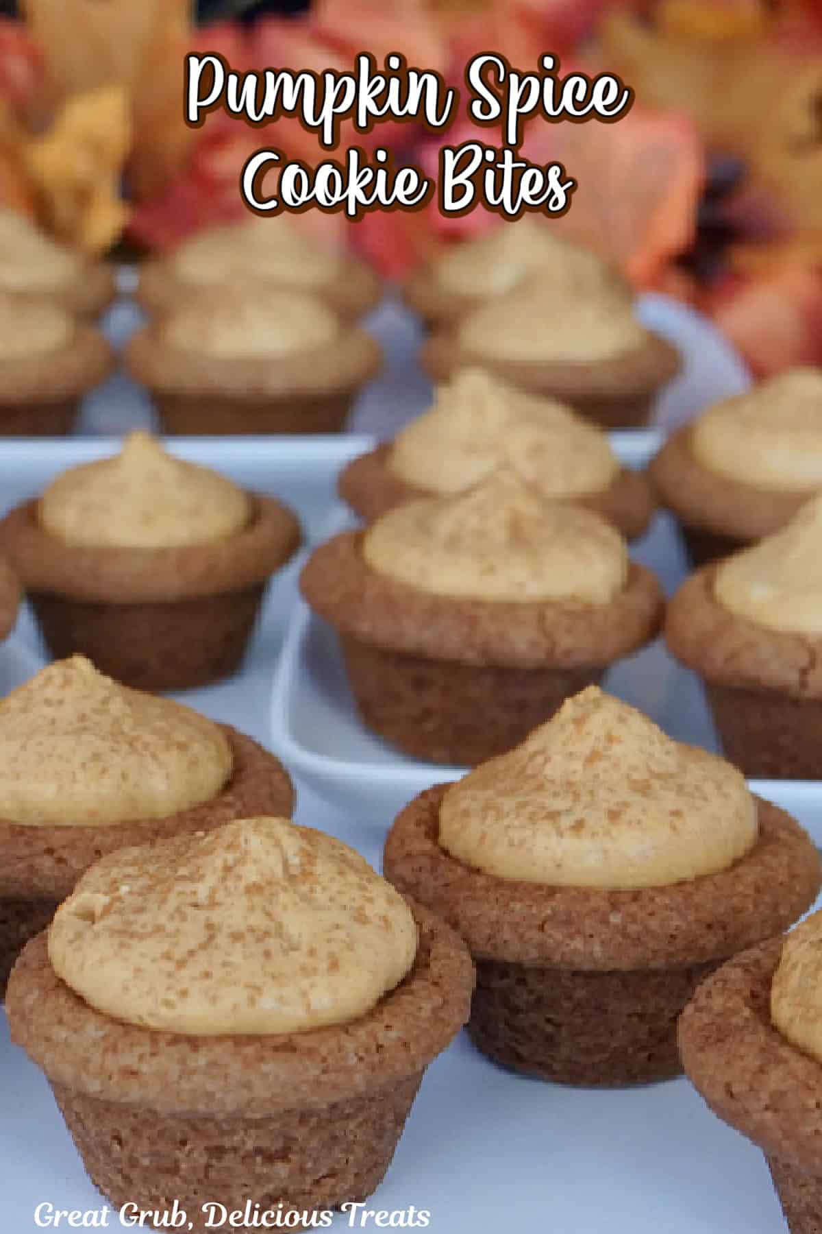 A white surface with over a dozen mini pumpkin spice cookie bites on it.