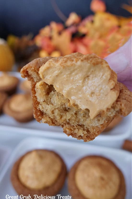 A mini cookie cup with pumpkin spice filling in it with a little bite taken out.