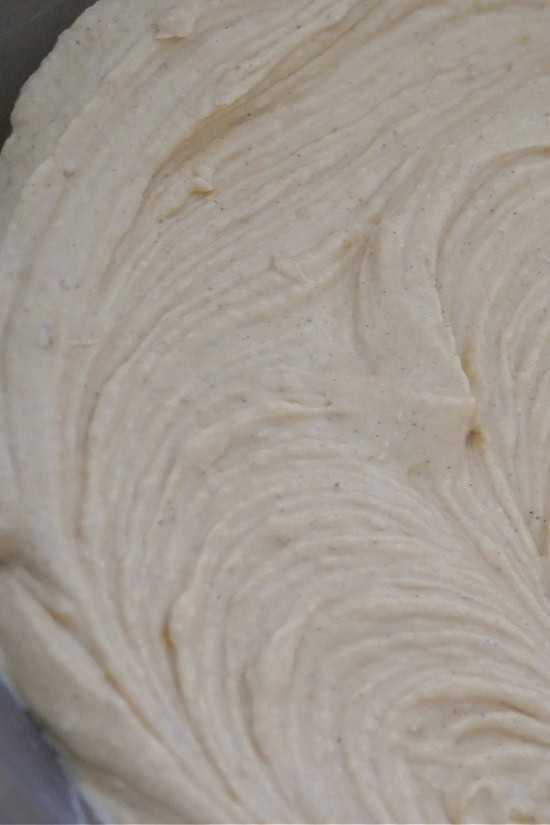 A mixing bowl with cream cheese, pumpkin puree and spices mixed together.