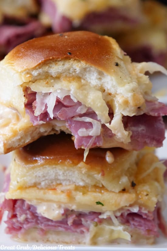 Two sliders stacked on top of each other on a white plate.