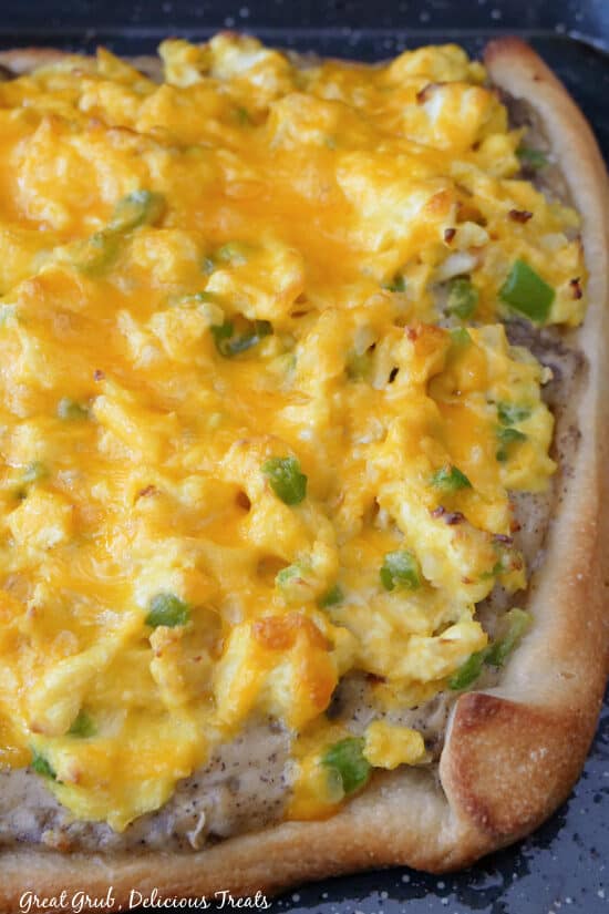 A photo of a homemade breakfast pizza before it was cut into slices.