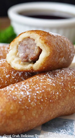 A close up of a sausage pancake on a stick with a bite taken out of it.