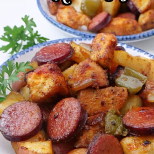 Two white bowls with blue trim with a serving of chicken, sausage, potatoes, onion and peppers, in them.