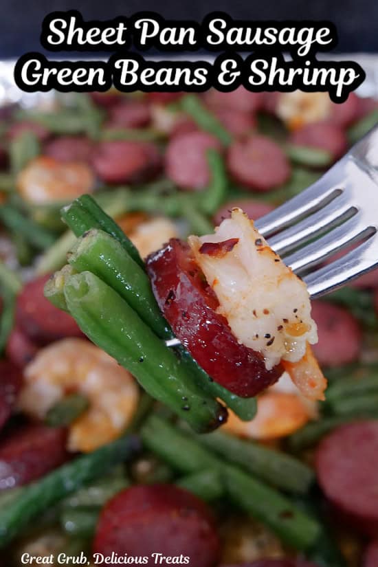 A bite of shrimp, sausage, and green beans on a fork.