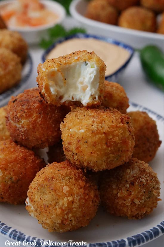 A small stack of fried shrimp poppers pile in each other with a bite taken out of the popper on top.