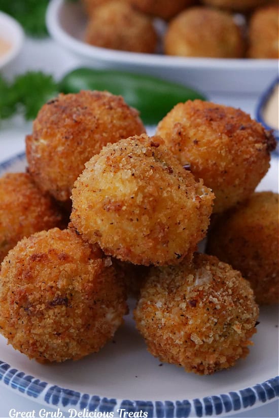 Eight shrimp poppers on a white round plate with blue trim.