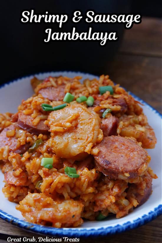 A white bowl with blue trim filled with a serving of shrimp and sausage jambalaya.