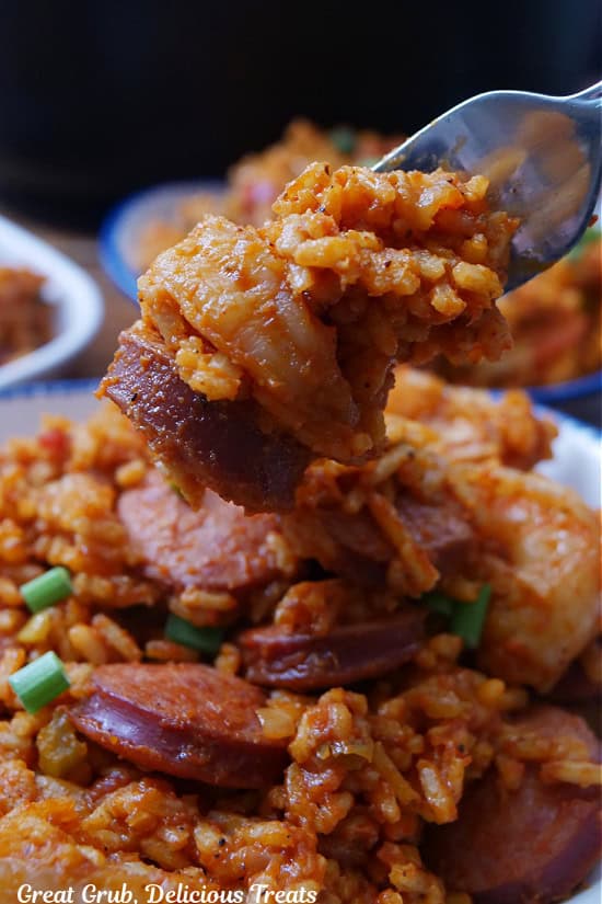 A bite of sausage and shrimp jambalaya on a fork.