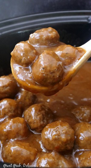 A crock pot full of meatballs covered in gravy.