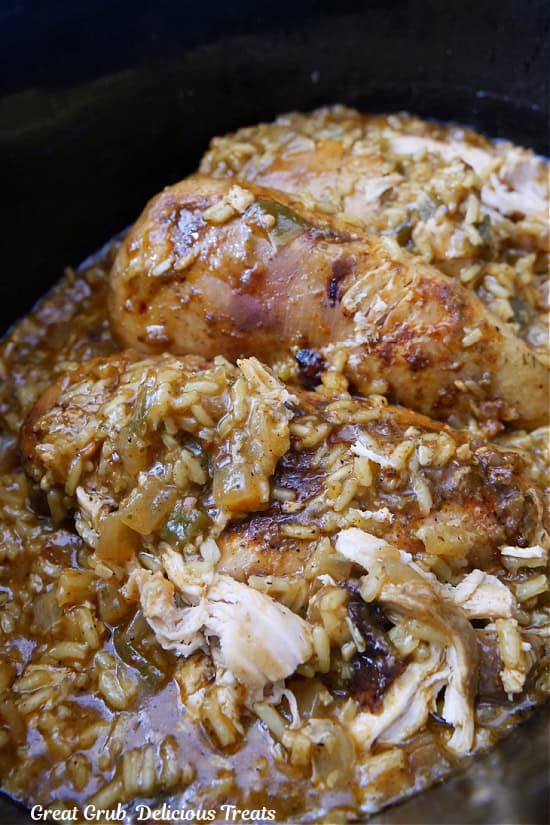 A crock pot filled with chicken and rice.