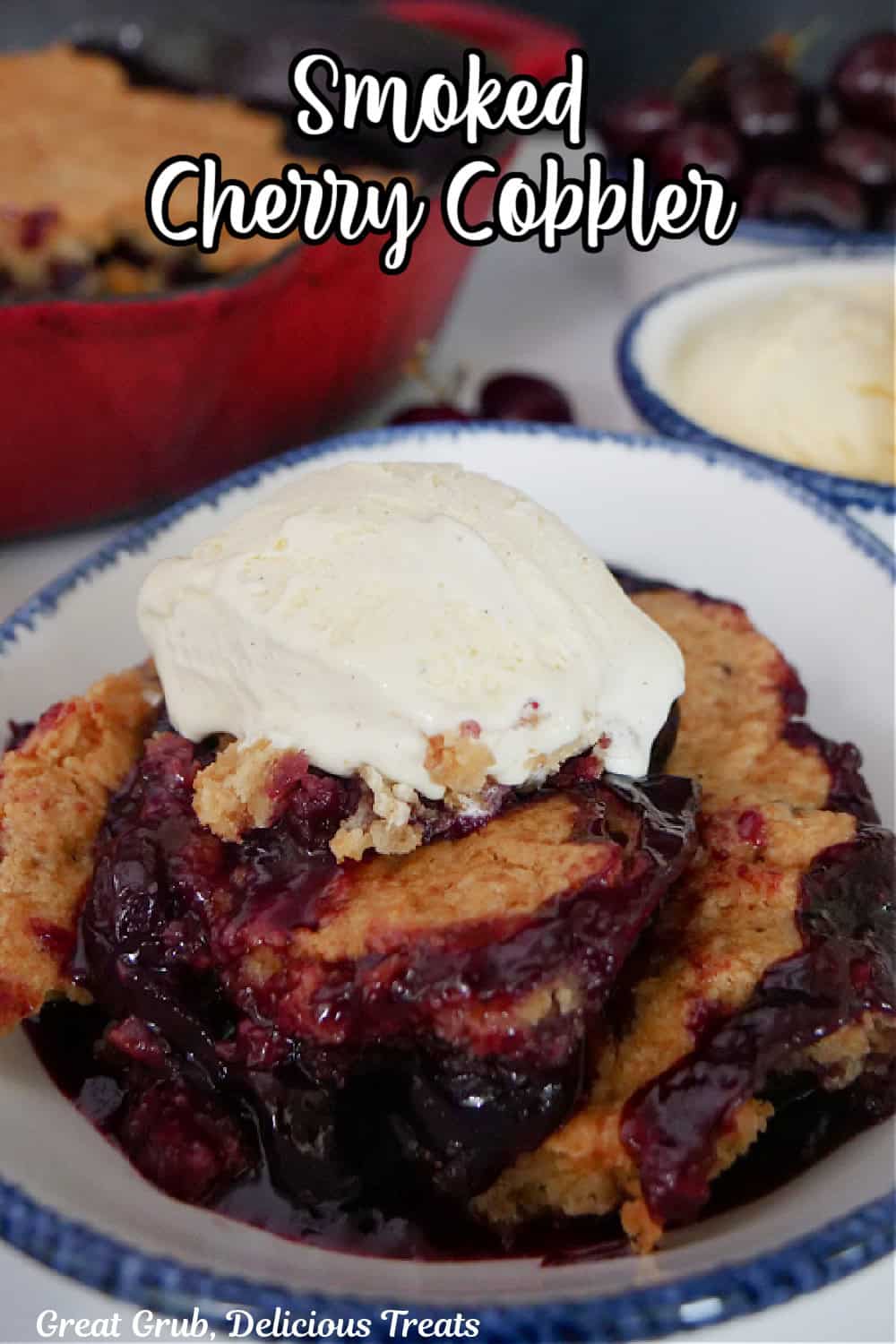 A white bowl with blue trim filled with a serving of smoked cherry cobbler with a scoop of vanilla ice cream on top.