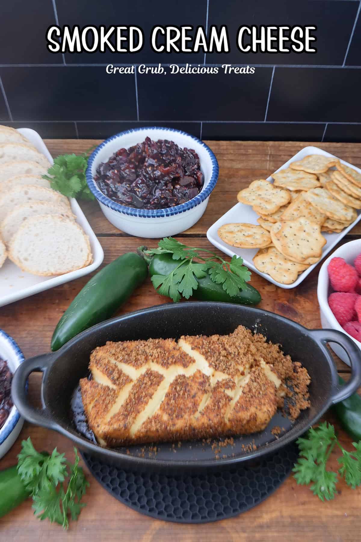 A wood surface with an oval black dish with a smoked cream cheese brick