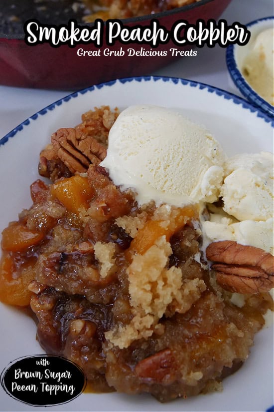 A white bowl with blue trim filled with a serving of smoked peach cobbler with two small scoops of vanilla ice cream.