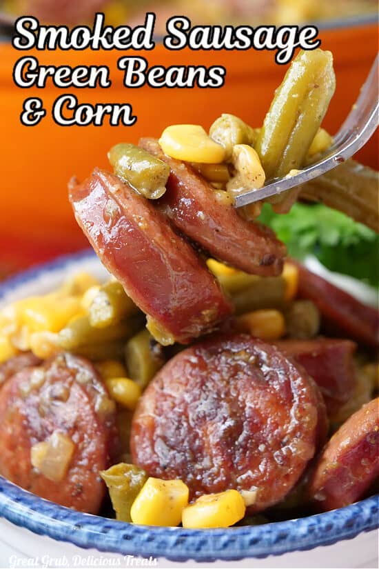 A close up of a fork with a bite of sausage, corn, green beans with the title of the recipe at the top of the photo.