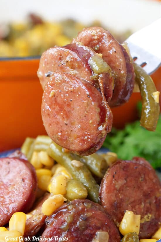 A super close up photo of three slices of sausage on a fork.