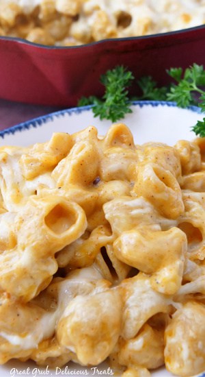Smoked Mac and Cheese is creamy, cheesy, seasoned perfectly, and is packed full of delicious flavors. A close up picture of mac and cheese in a white bowl with blue trim.