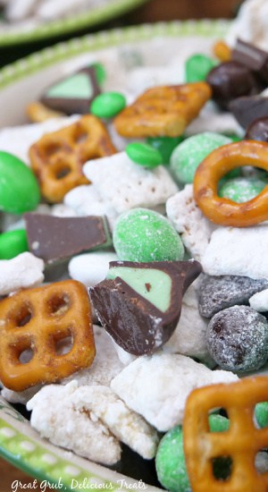 A close up of St Patrick's day muddy buddies mix in a green and white bowl.