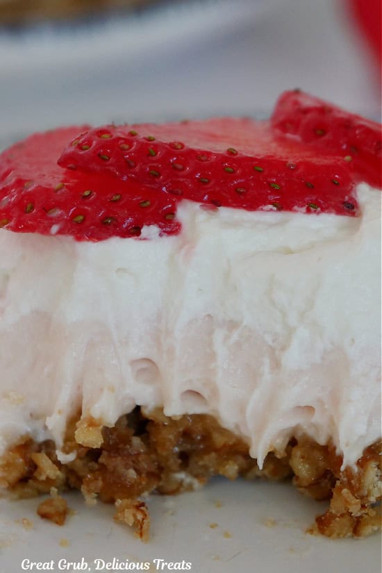 A slice of strawberry pretzel dessert with a few bites out of it.
