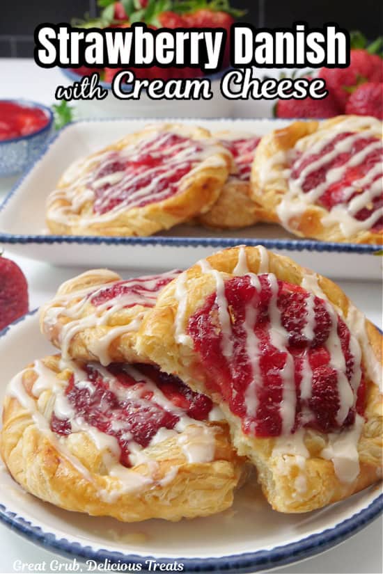 Two white plates with blue trim with strawberry danishes on them.