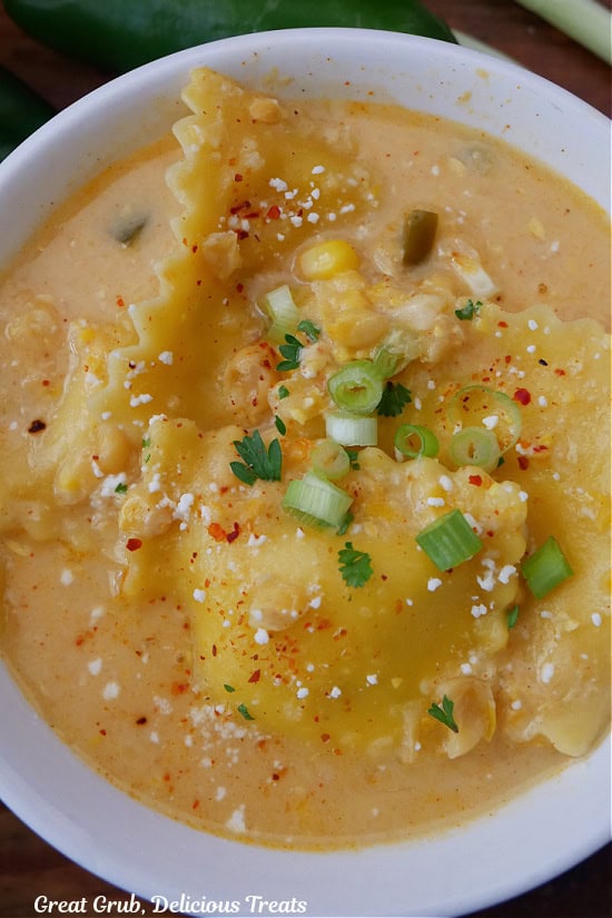 A white bowl filled with street corn ravioli soup.