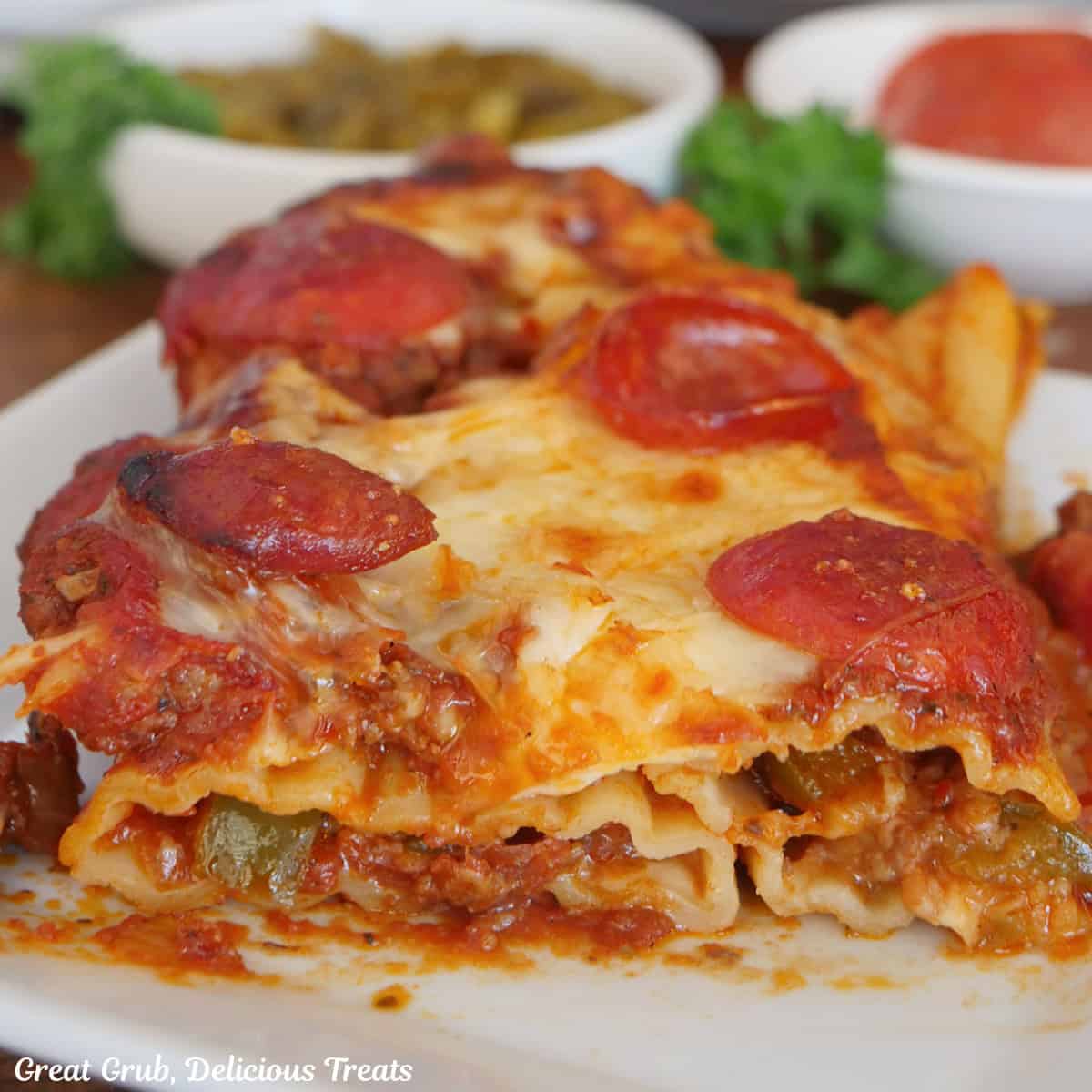 A white plate with a serving of supreme pizza stuffed manicotti on it.
