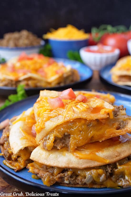 A blue plate with a Mexican pizza copycat Taco Bell recipe on it that has been cut and one piece is placed on top of another piece.