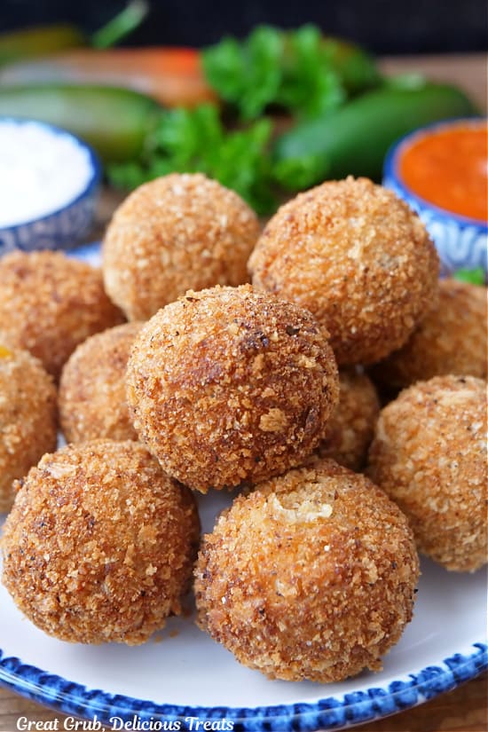 A dozen crispy, deep-fried cheese bites on a white plate.