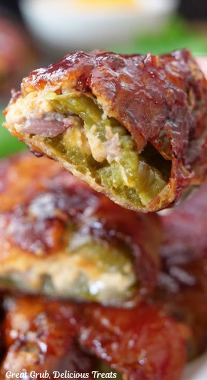 A close up photo of stuffed jalapenos wrapped in bacon with leftover brisket in it.