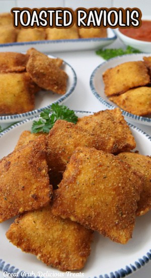 Deep fried raviolis on white plates with blue trim.