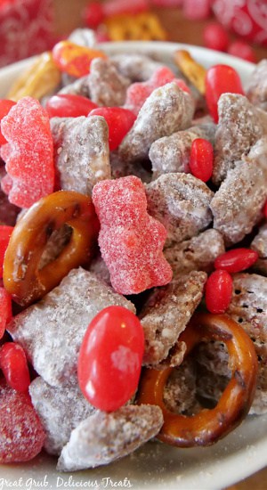 Valentine Puppy Chow Mix is a great recipe to make for a weekly snack, for lunchboxes, or classroom snacks. A close up of a white bowl filled with Valentine puppy chow mix.