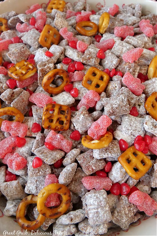 Valentine Puppy Chow Mix is a delicious snack made with cinnamon Chex cereal, cinnamon candies, pretzels, chocolate chips, and tossed in powdered sugar. A close up of all the ingredients in Valentine Puppy Chow.