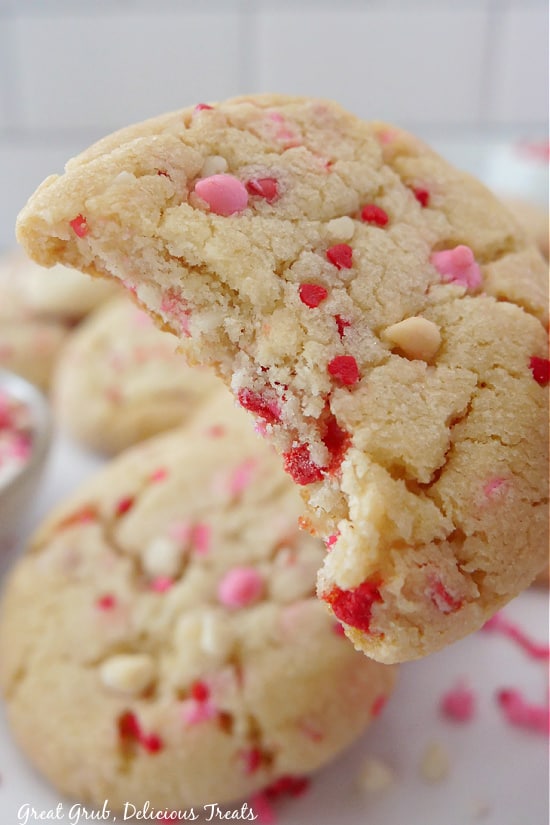 Valentine Sugar Cookies are soft and delicious sugar cookies that are loaded with Valentine’s Day sprinkles. A close-up picture of a sugar cookie with a bite taken out.